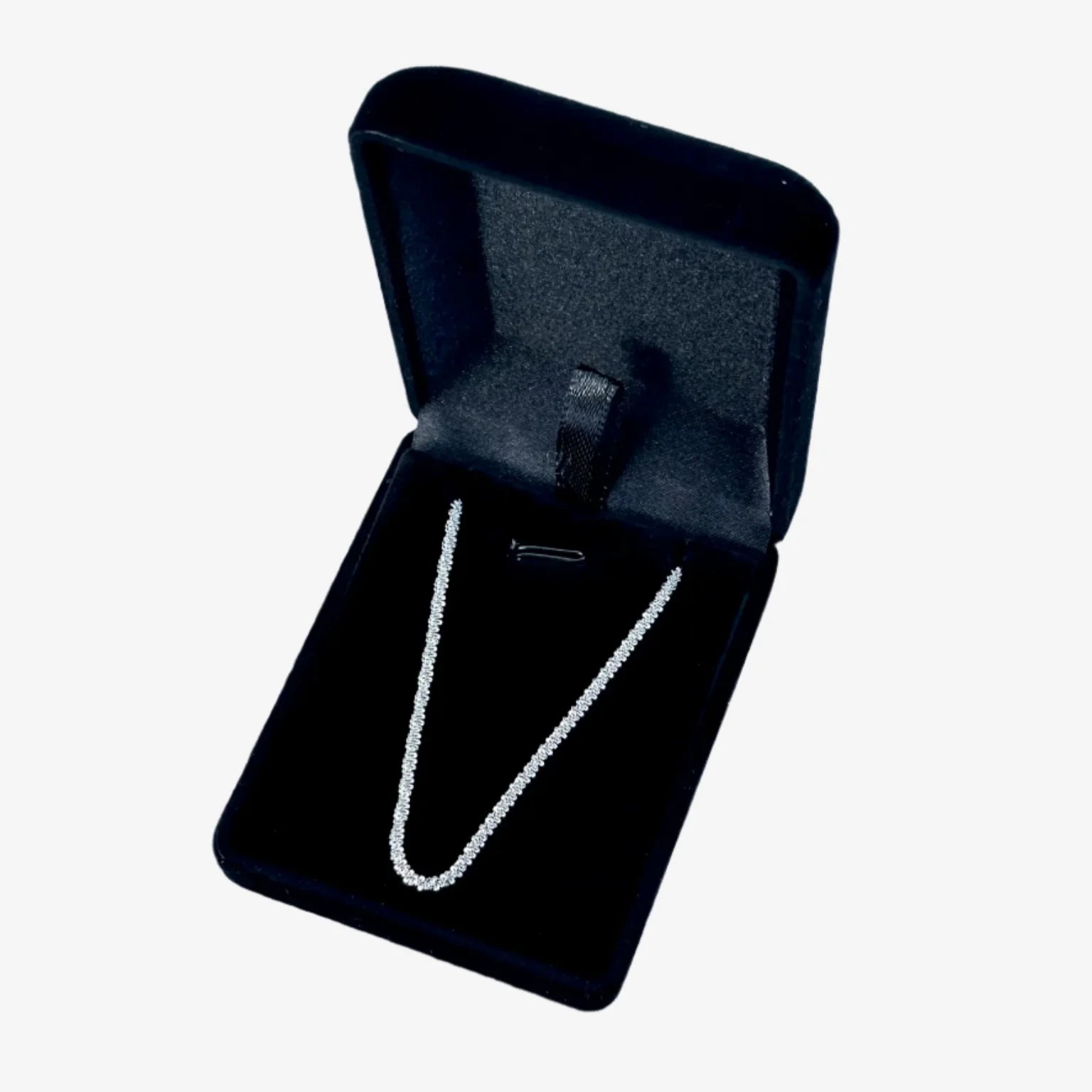 Black jewelry box with a silver necklace on a light blue background