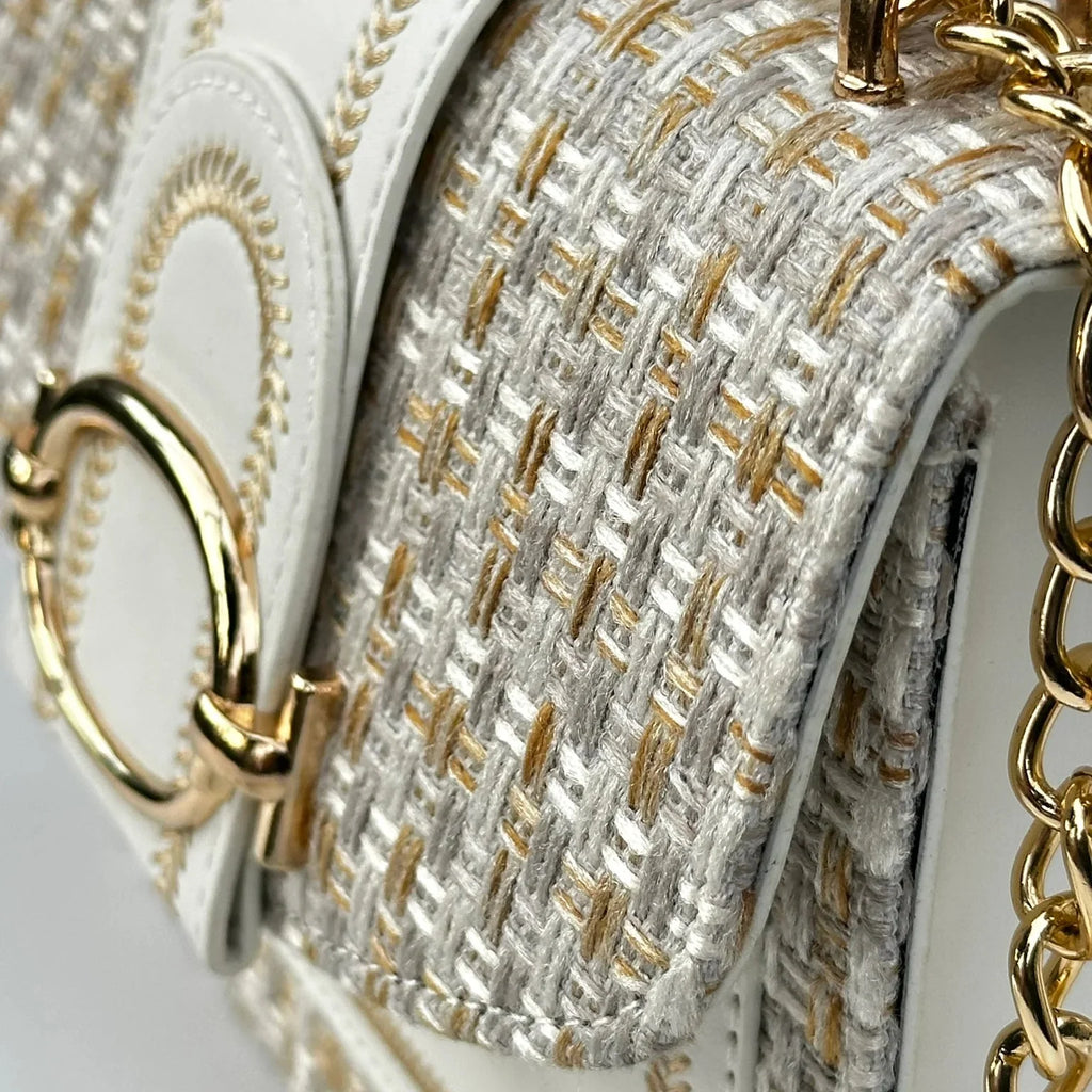 Close-up of a handbag with gold chain and textured fabric