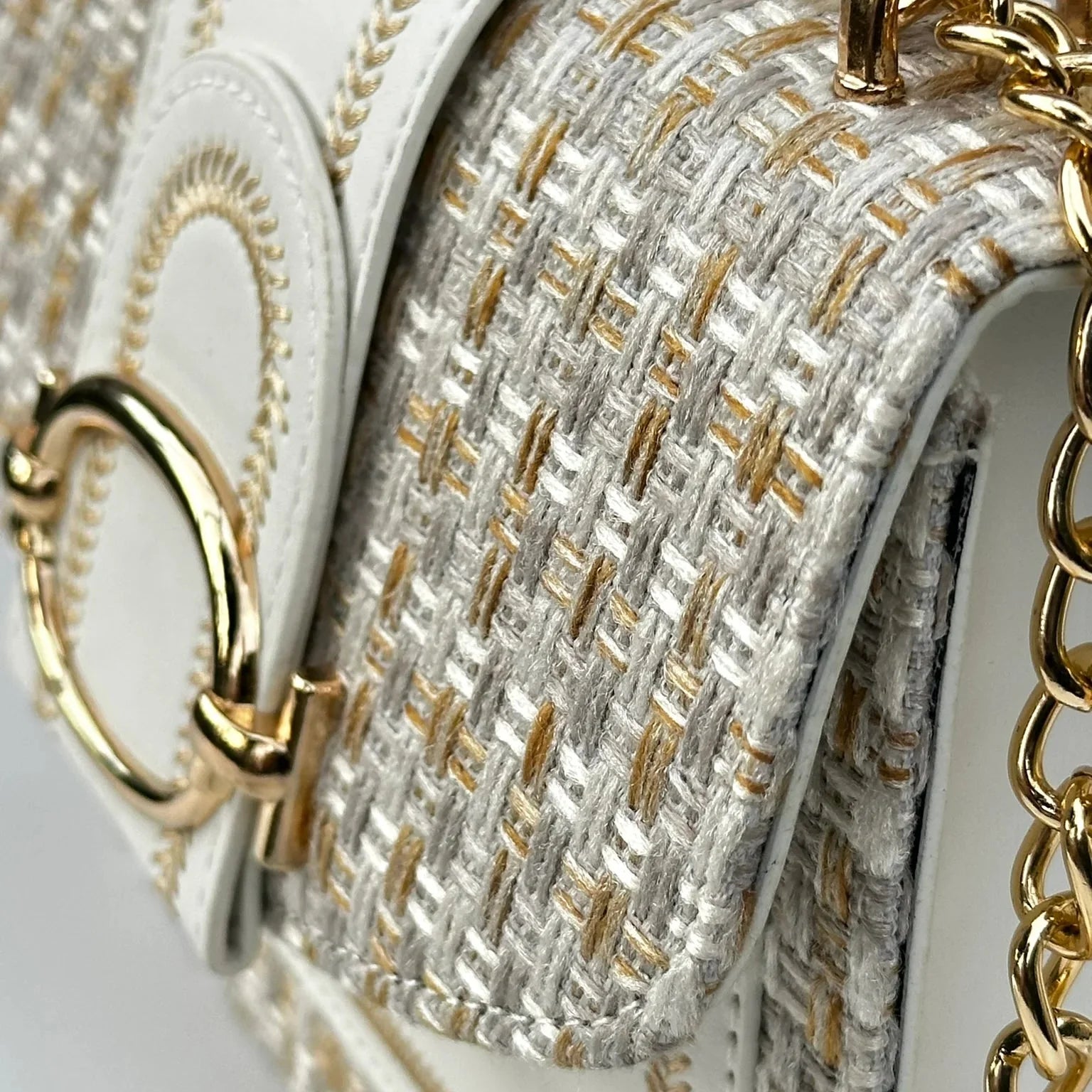 Close-up of a handbag with gold chain and textured fabric