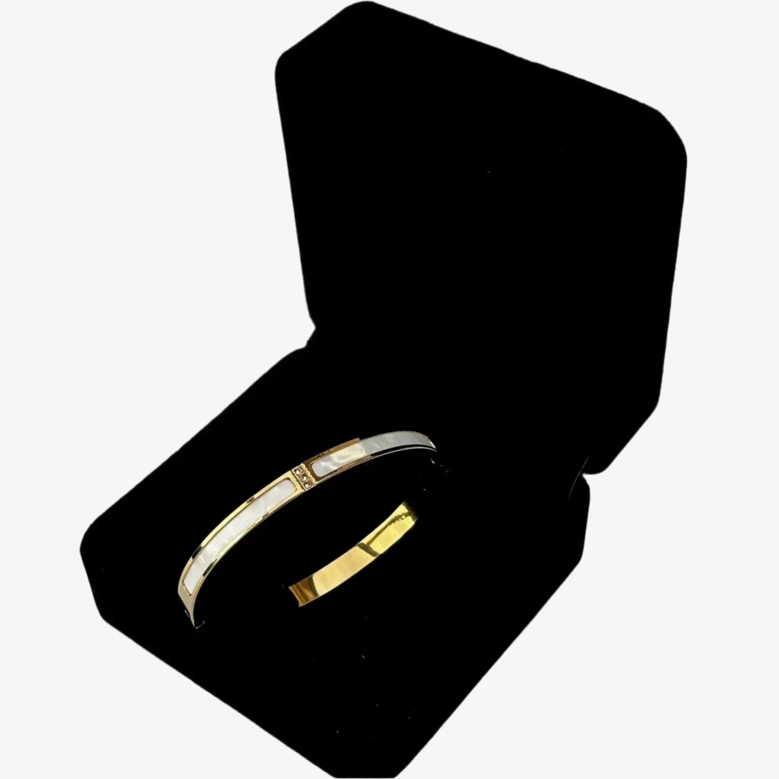 Gold and silver bracelet in a black velvet box on a light gray background