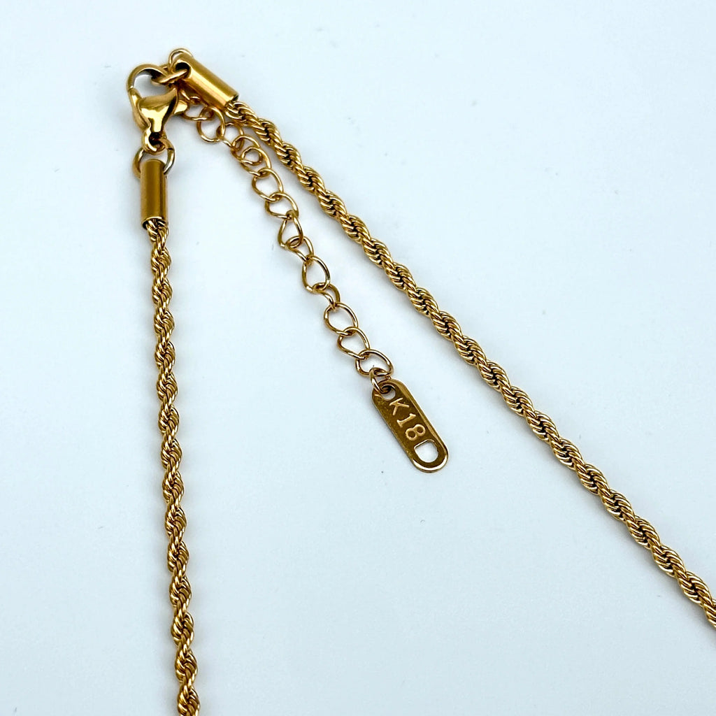 Gold chain necklace with a clasp on a white background