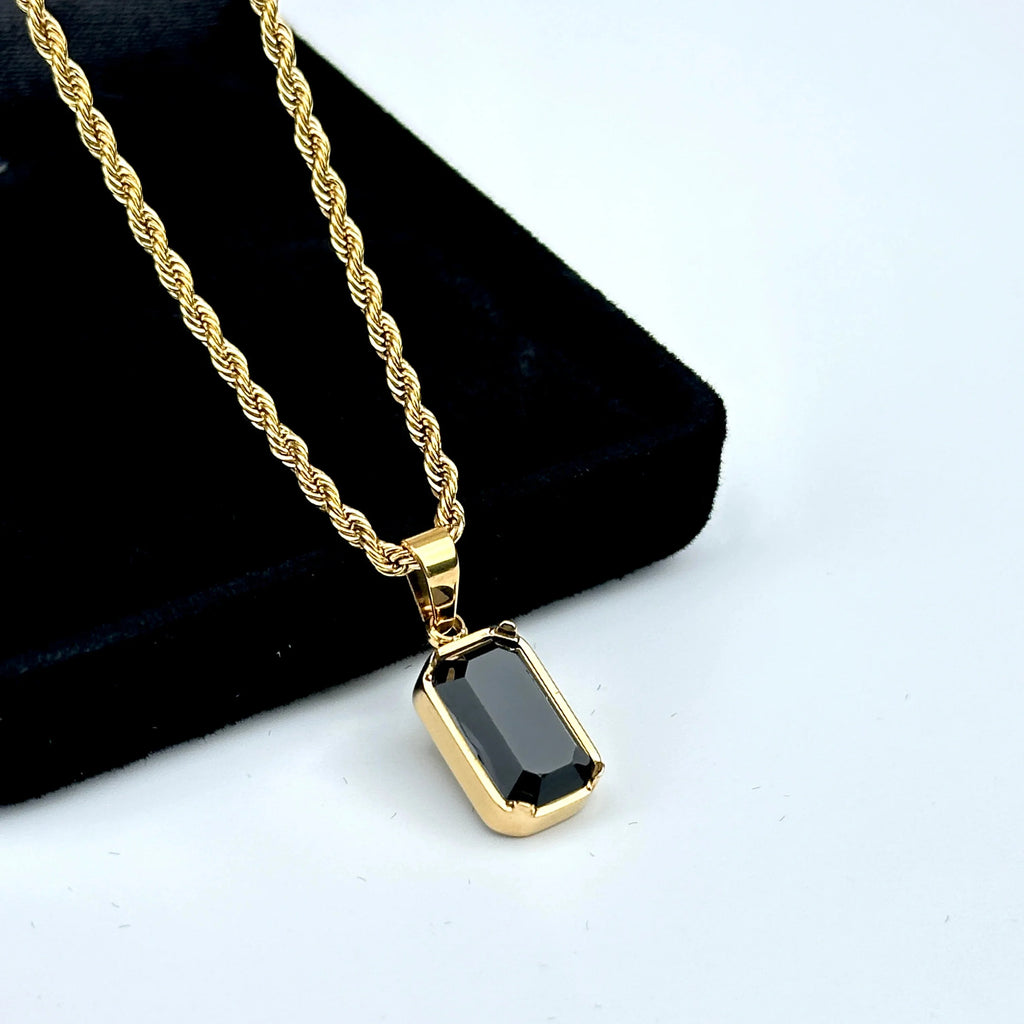 Gold necklace with a black pendant on a white background