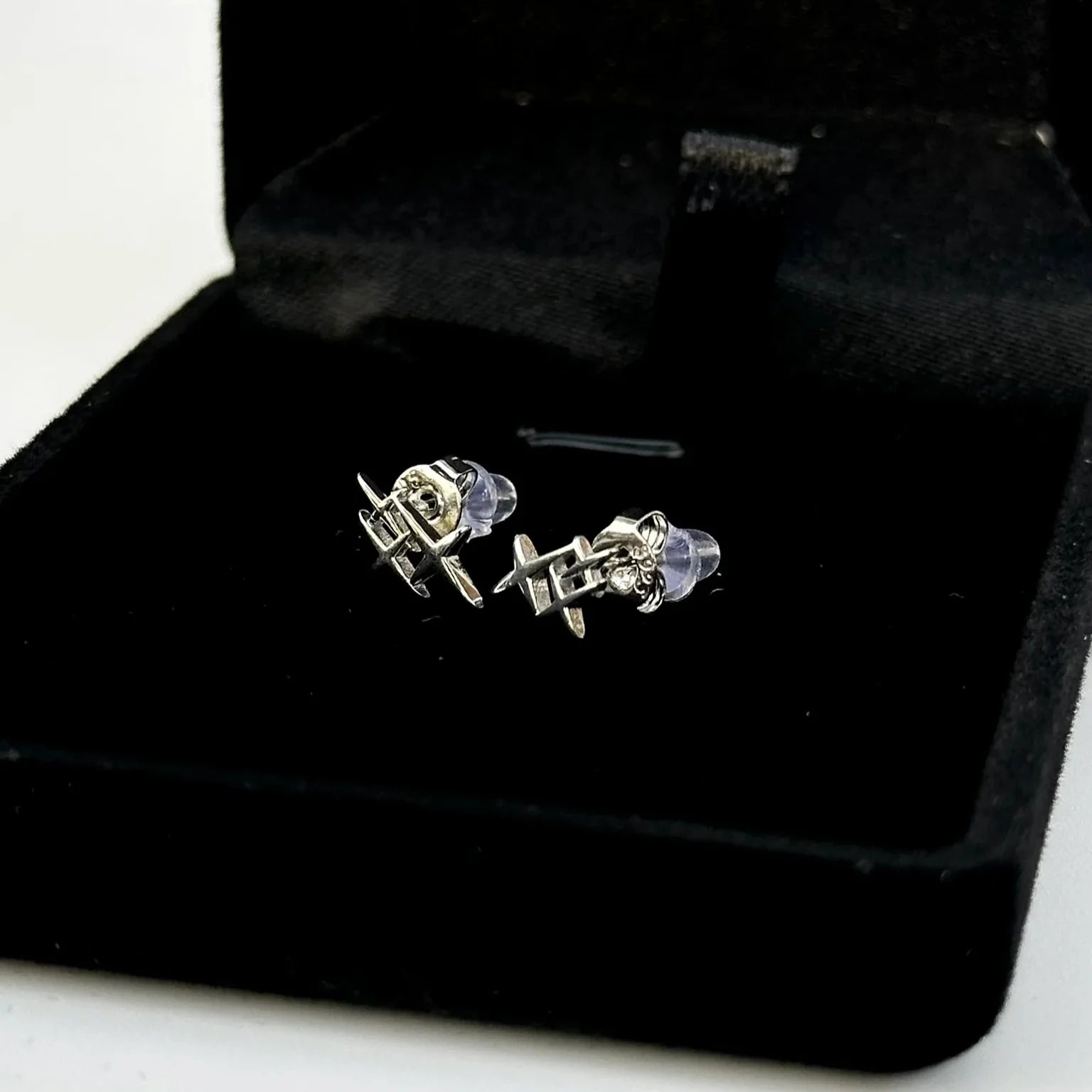 Pair of silver earrings in a black jewelry box on a white background