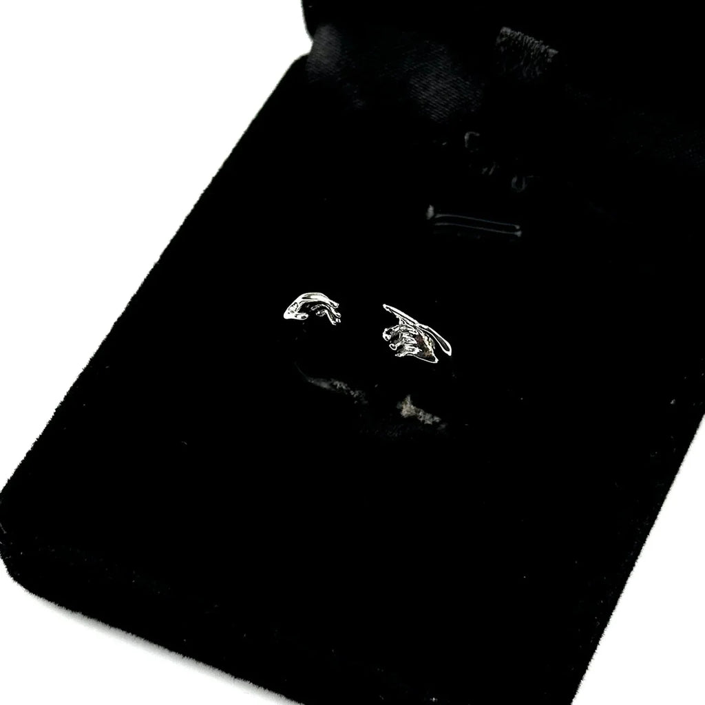 Pair of silver earrings on a black card with a white background