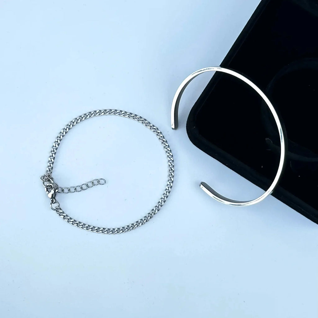 Silver bracelet and ring on a light blue background
