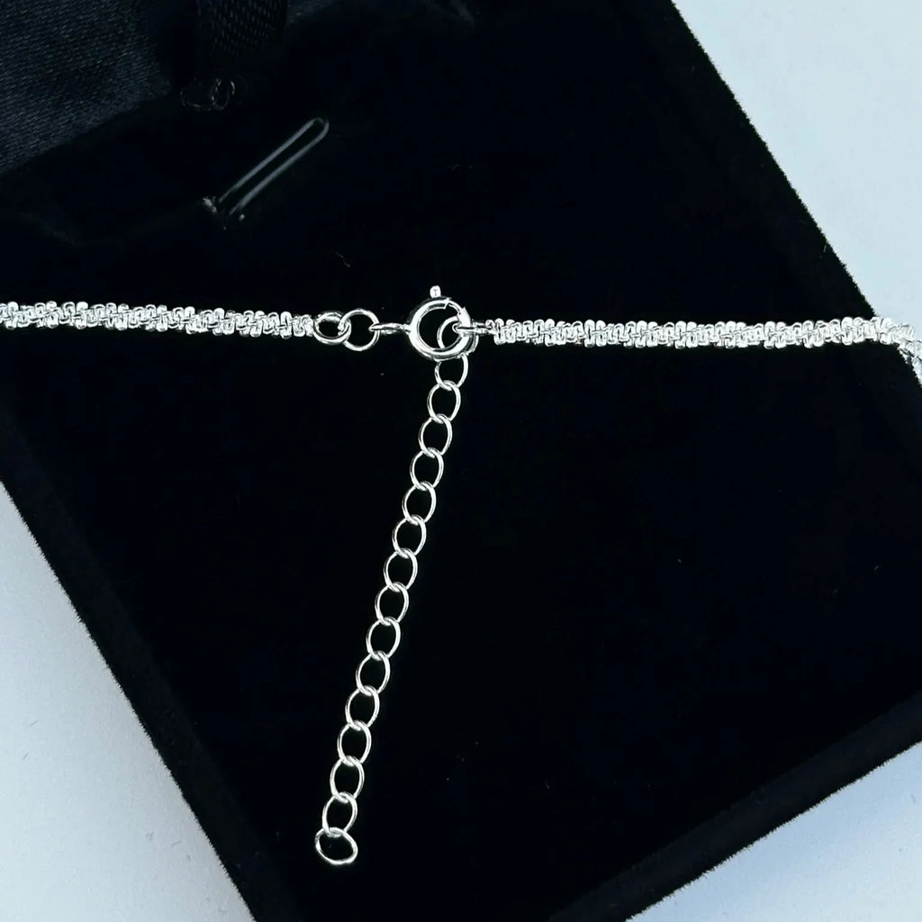 Silver chain necklace on a black jewelry box