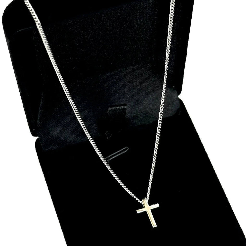 Silver cross necklace on a black velvet stand