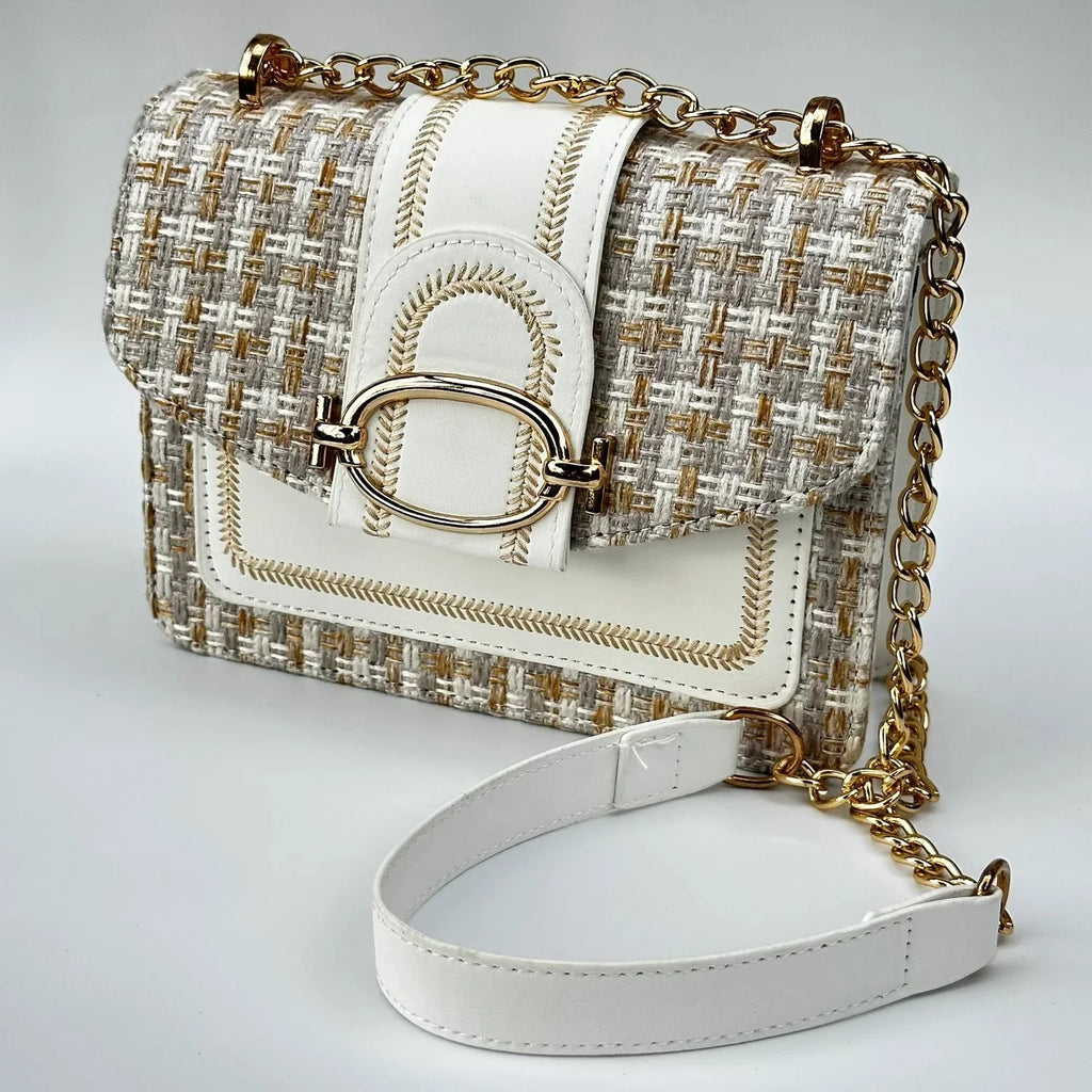 White and gold handbag with chain strap on a light gray background