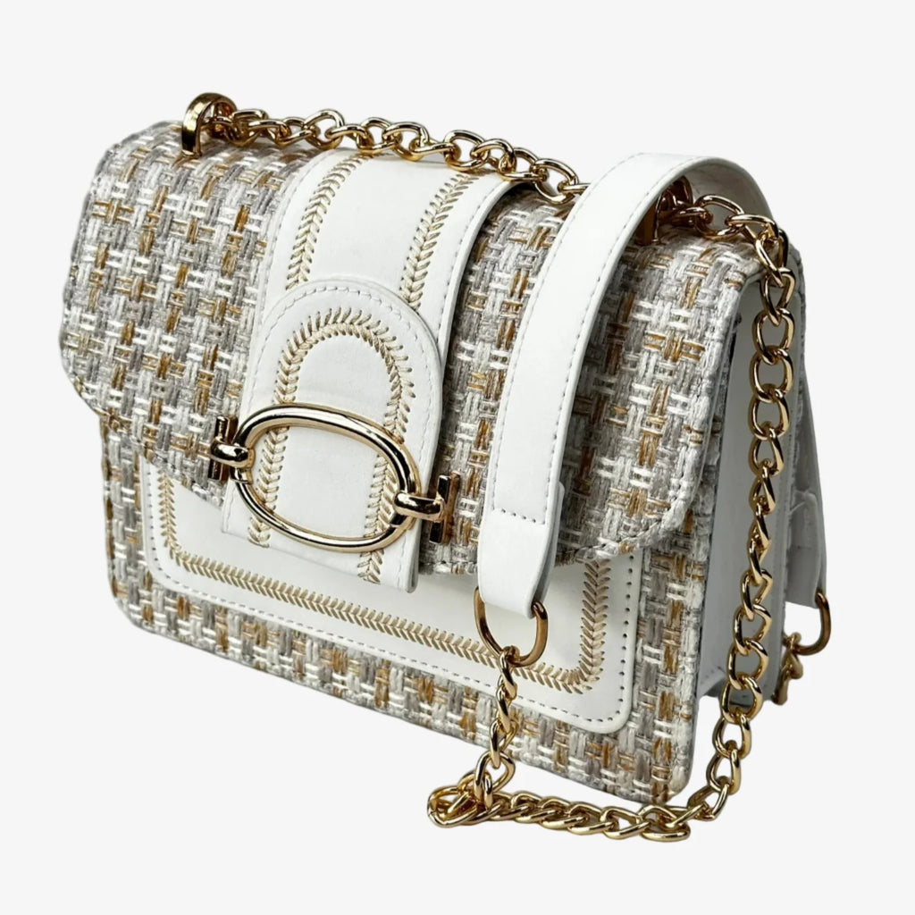 White handbag with gold chain strap on a light gray background