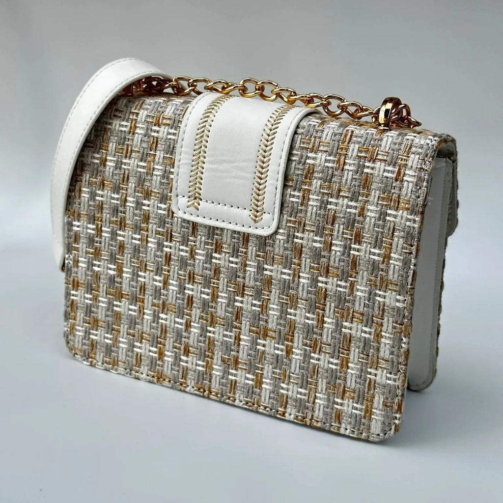 Woven handbag with gold chain strap on a gray background