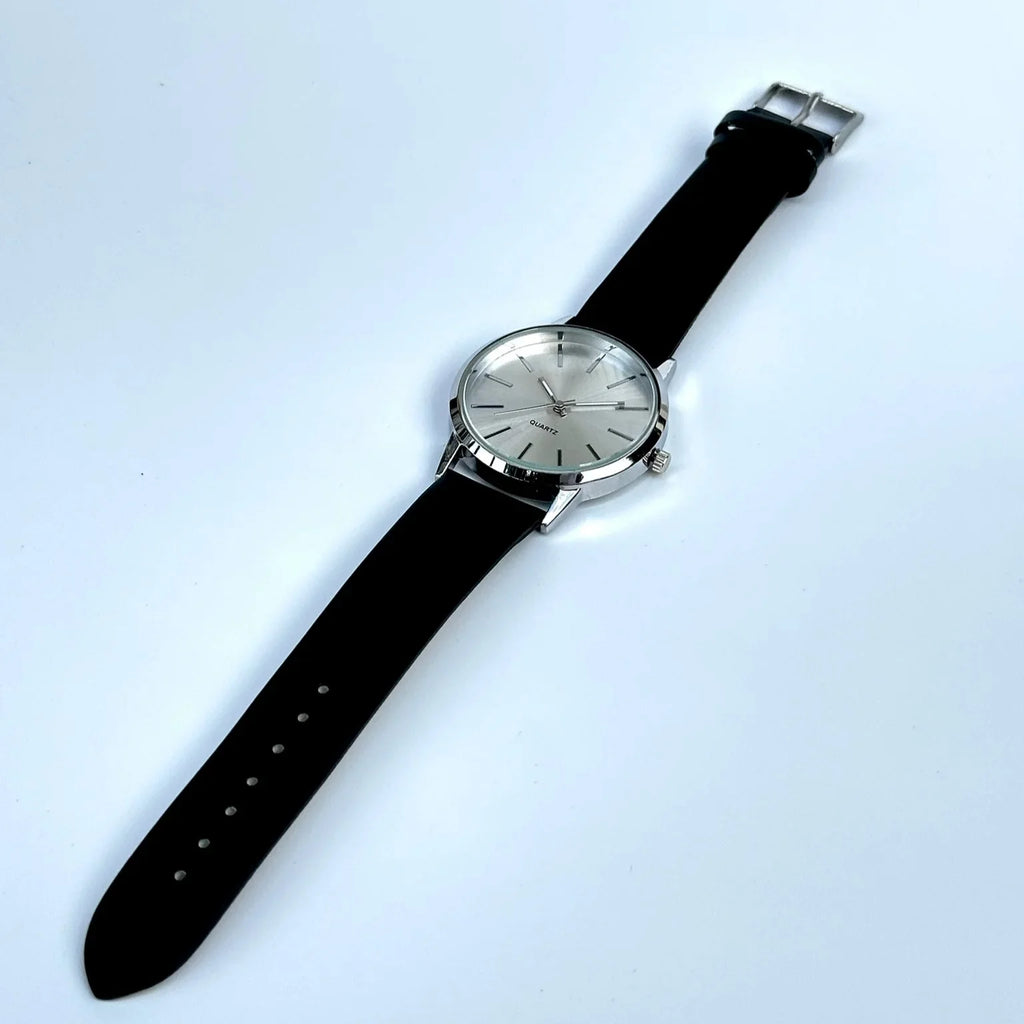 Wristwatch with black strap and silver case on a light blue background
